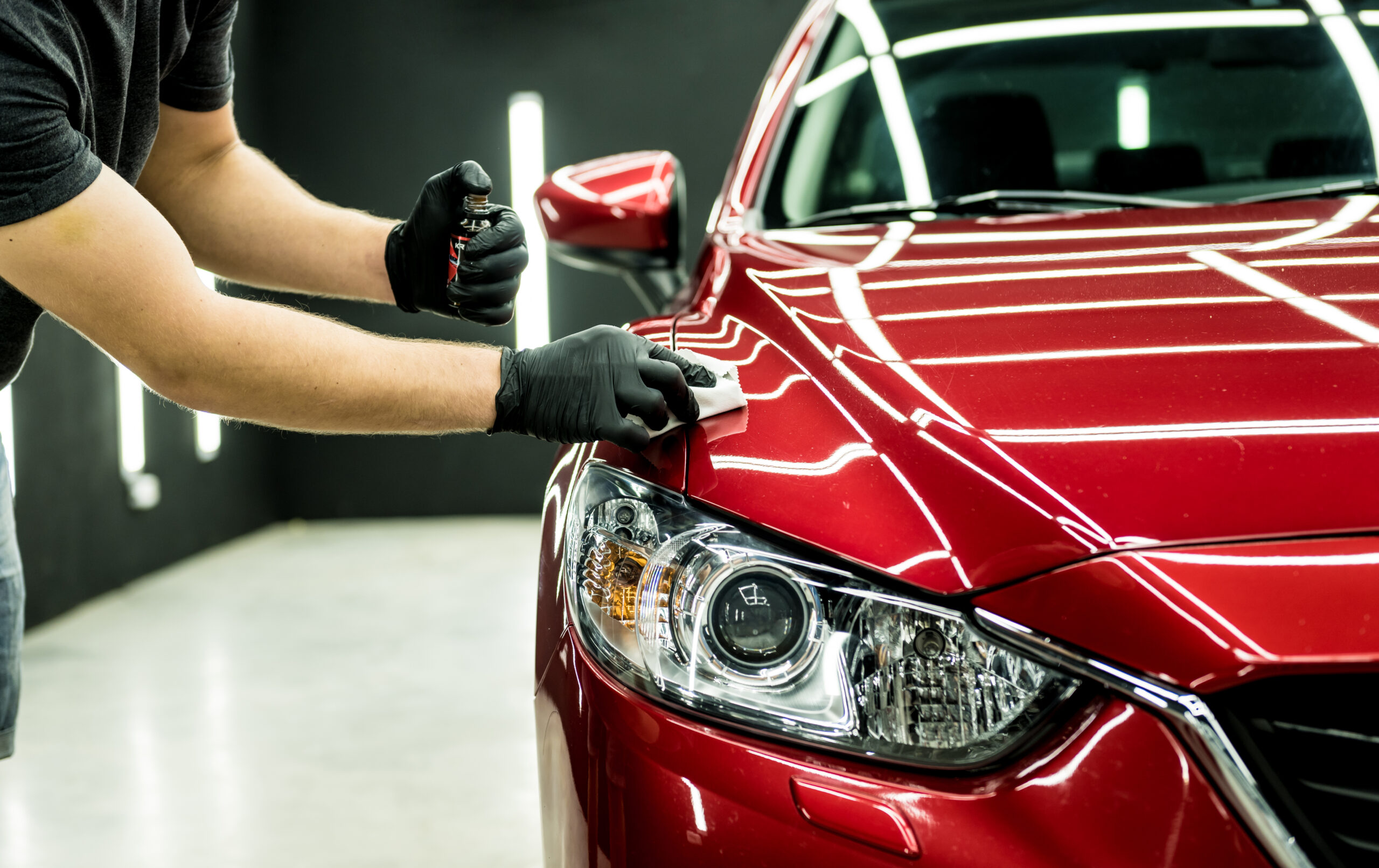 Car service worker applying nano coating on a car detail.